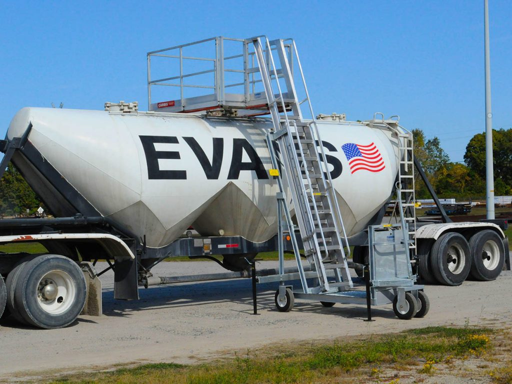 A Carbis portable tanker truck access system is pulled up onto a tank car.