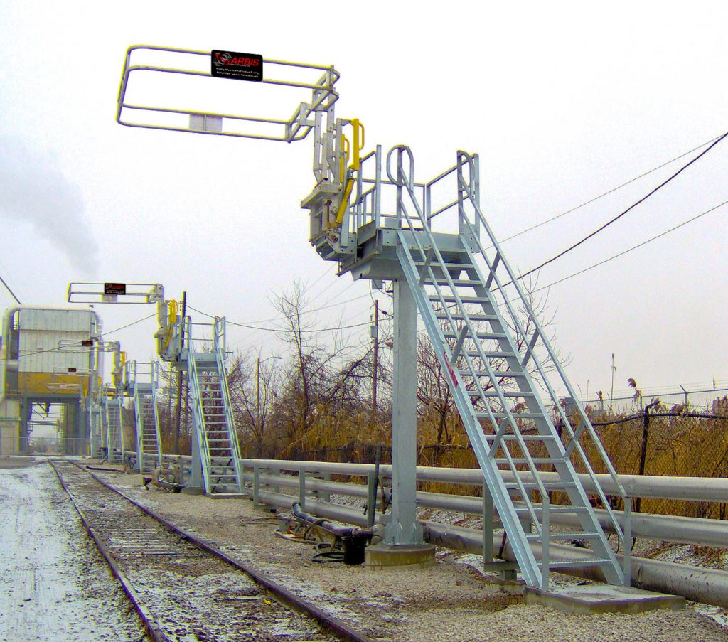 a few single car train access and loading systems on the side of a railroad track.