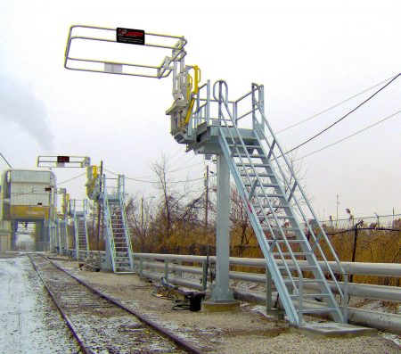 a few single car train access and loading systems on the side of a railroad track.