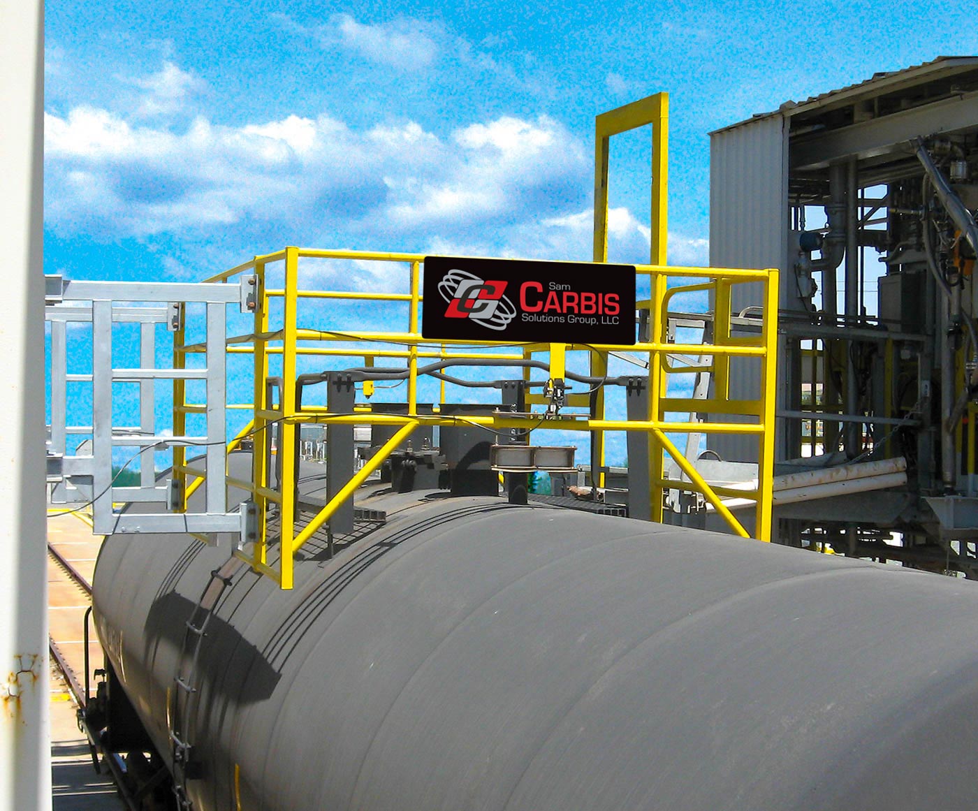 A Carbis Solutions safety cage is set upon a tanker railcar for loading and/or maintenance.