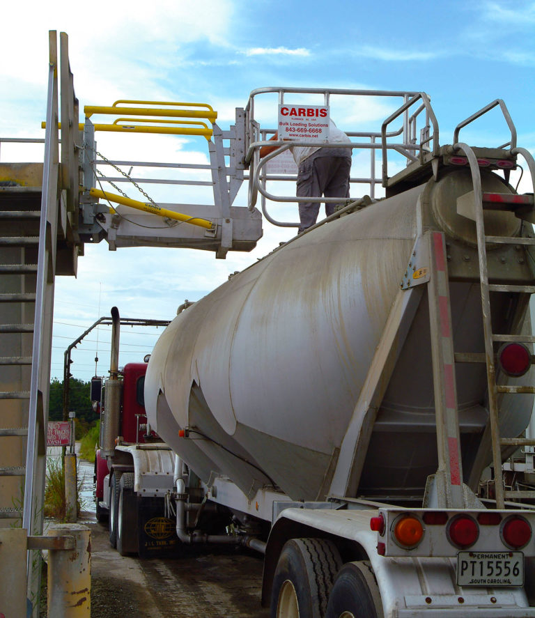 A worker on a gangway stands on top of a tanker truck.