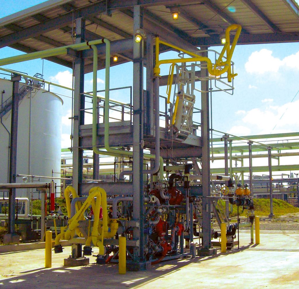 A top loading arm sits in a loading bay.