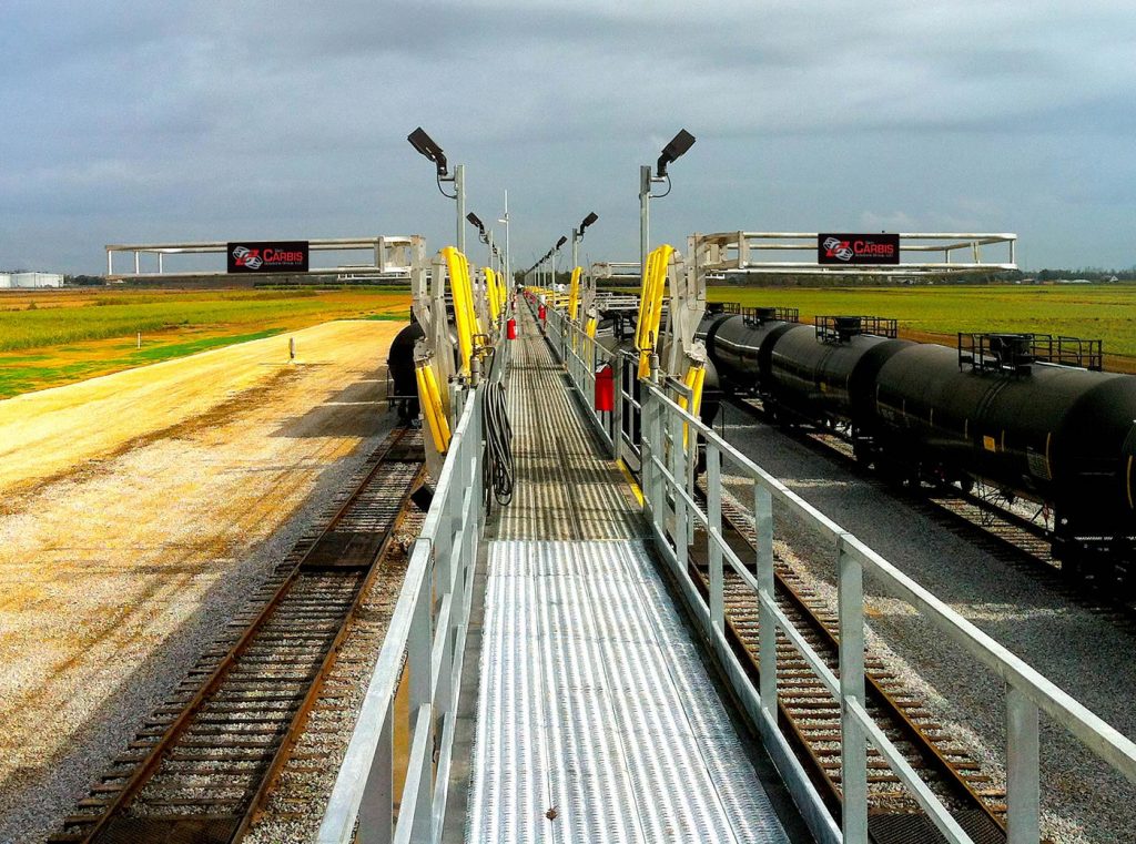 A series of railcar safety cages seen on a catwalk at a loading platform.