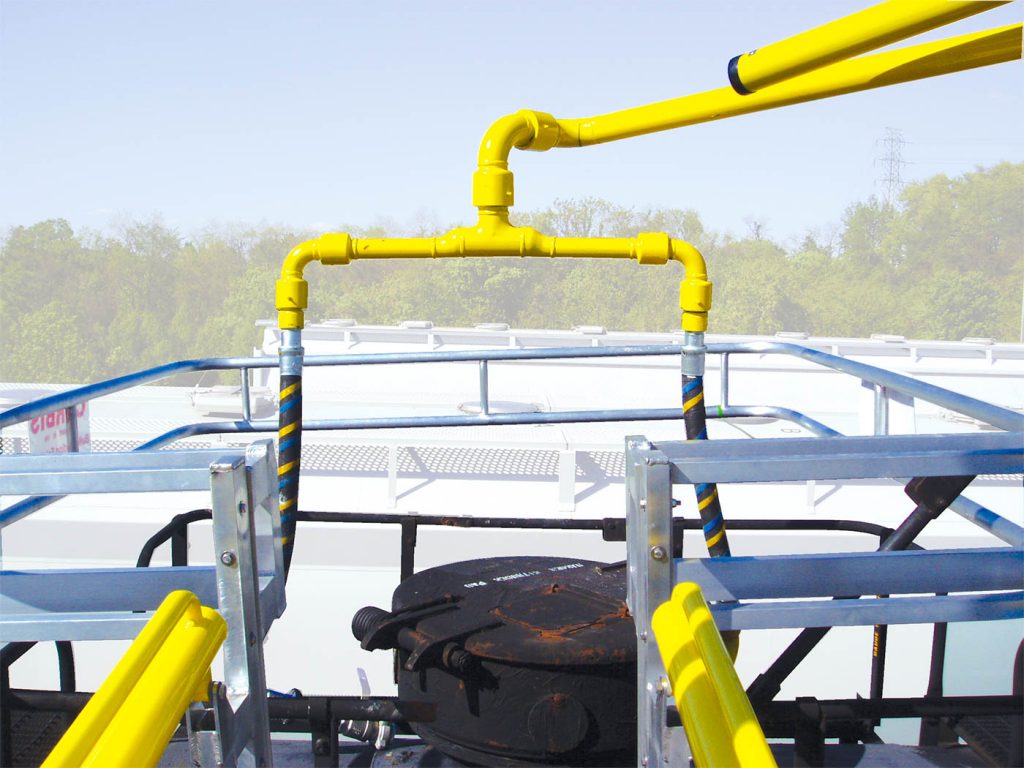 A top loading arm is shown with a safety cage over the top of a tanker railcar.